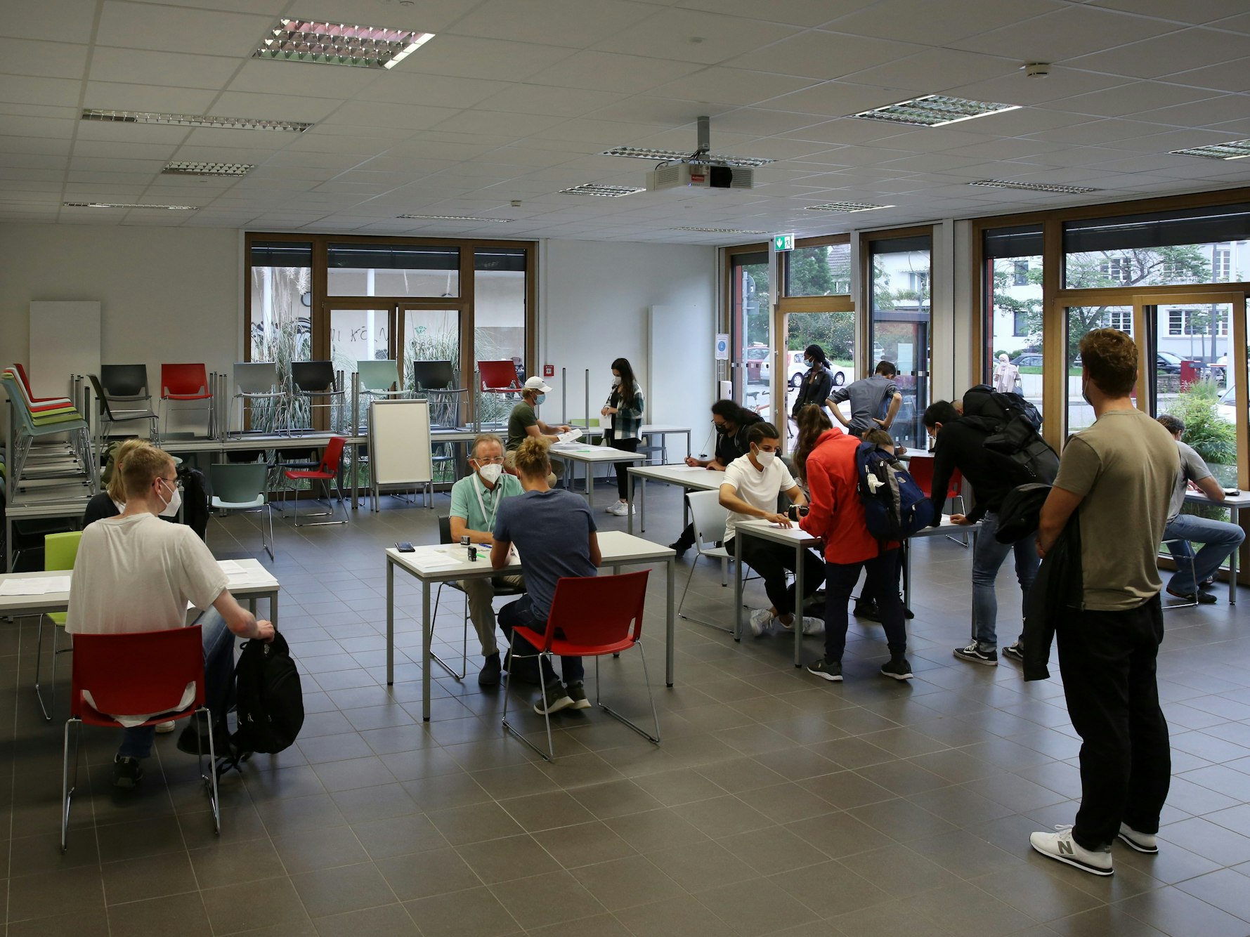 Studierende der Uni Köln warten in einem Raum auf ihre Impfung.