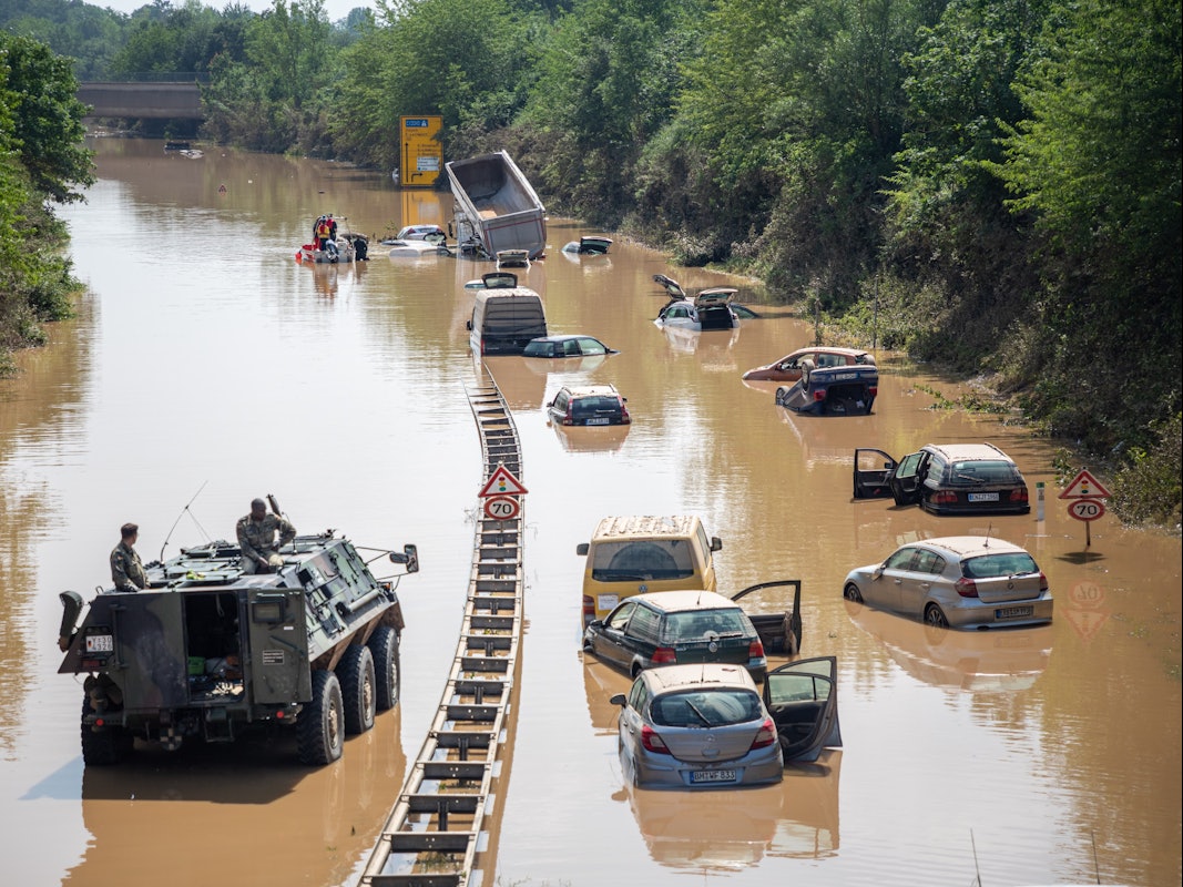 Rettungskräfte und Soldaten der Bundeswehr bergen die zerstörten Autos und Lkw auf der B265 Luxemburger Straße im Ortsteil Liblar.