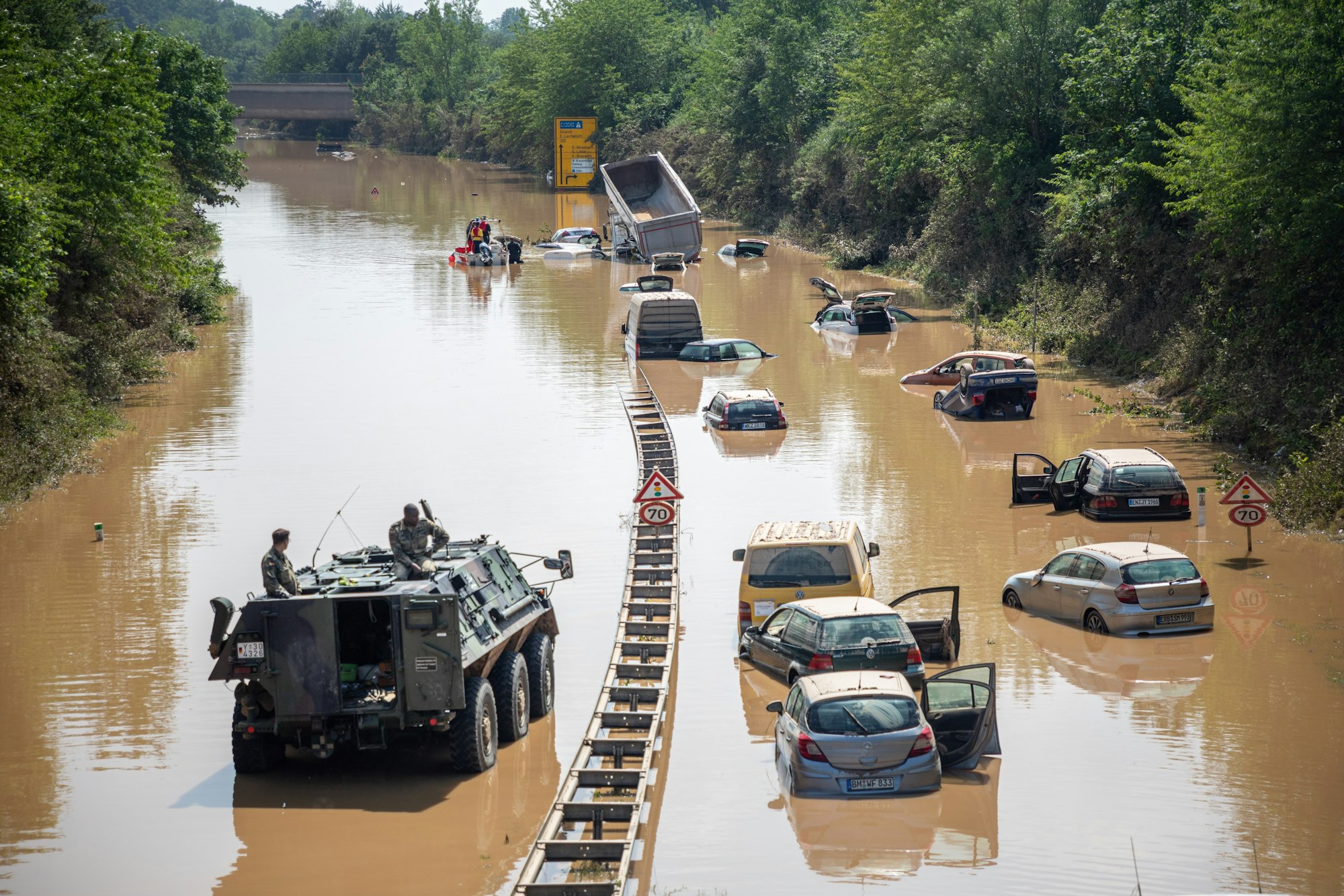 Rettungskräfte und Soldaten der Bundeswehr bergen die zerstörten Autos und Lkw auf der B265 Luxemburger Straße im Ortsteil Liblar.