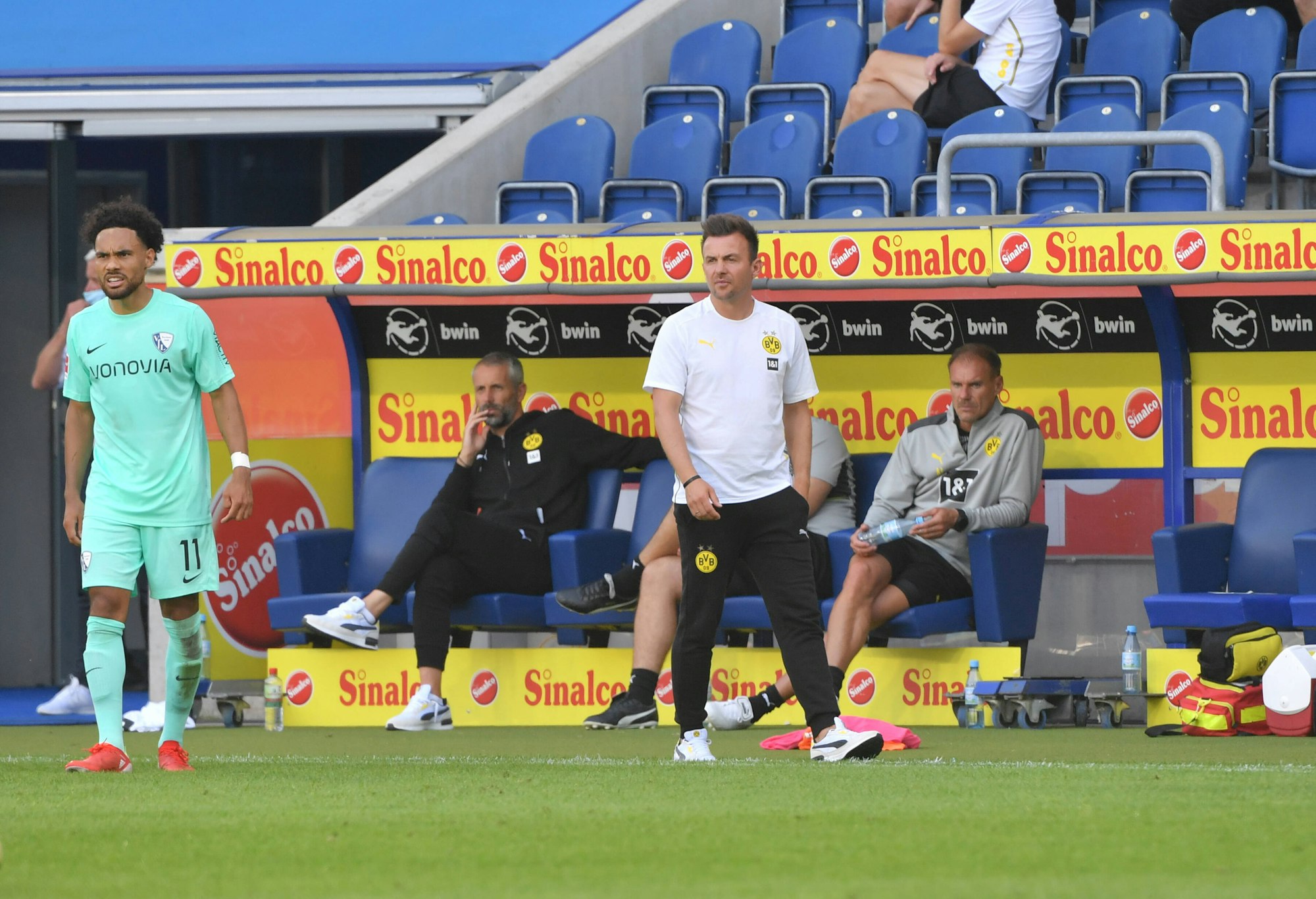 BVB U23-Trainer Enrico Maaßen an der Seitenlinie, Marco Rose sitzt im Hintegrund auf der Bank.