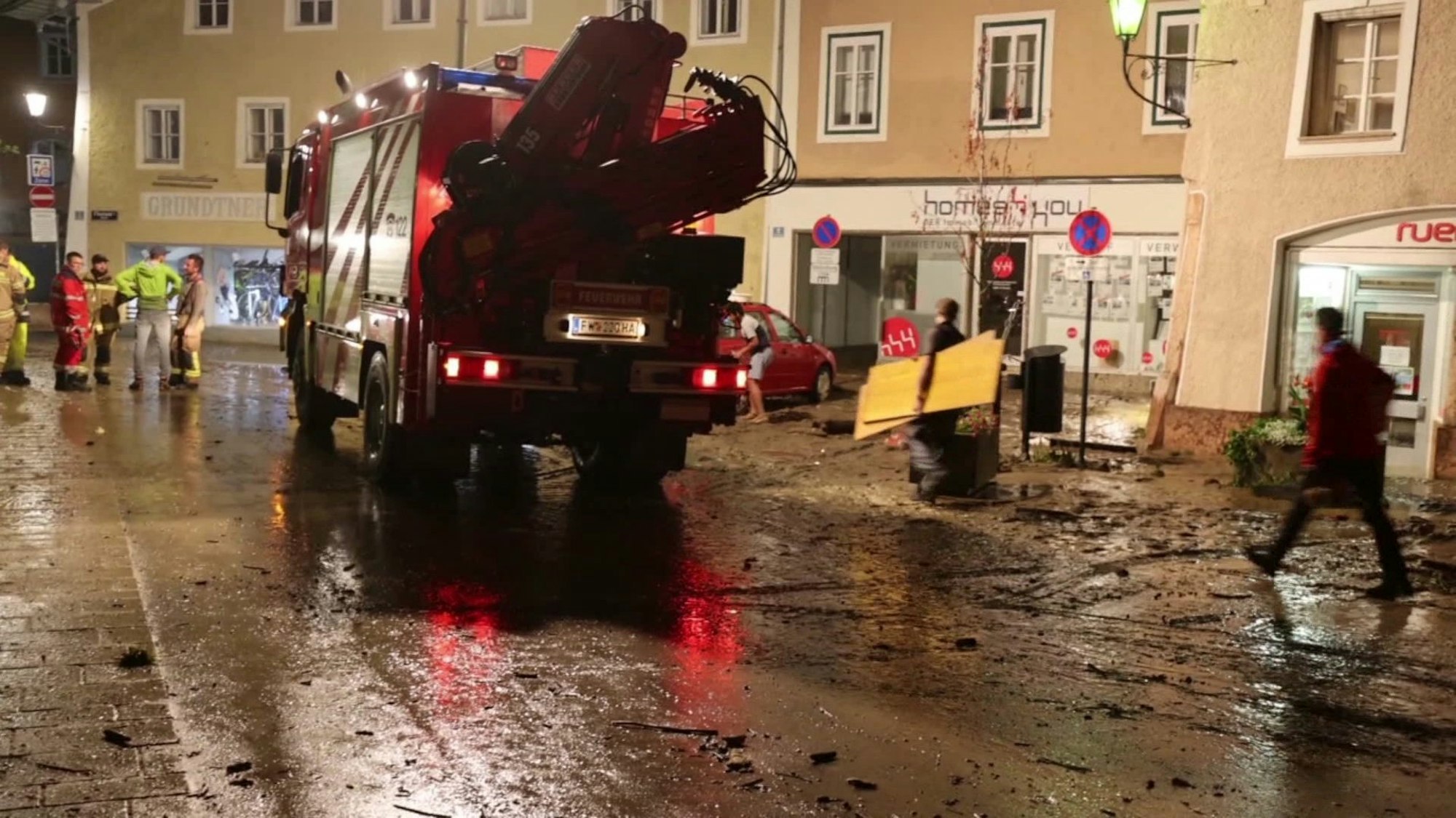 Unwetter Österreich: Nächtliche Aufräumarbeiten auf einer vom Hochwasser betroffenen Straße in der Altstadt von Hallein bei Salzburg.