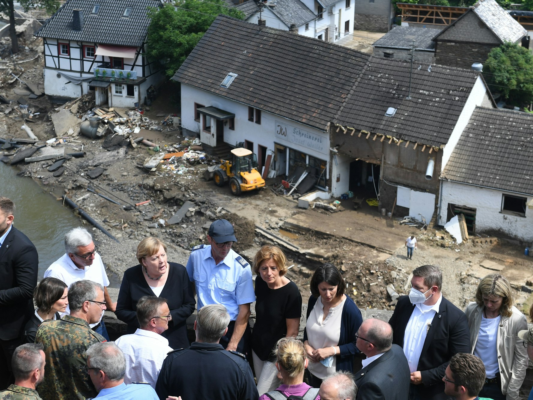 Bundeskanzlerin Angela Merkel (3.v.l.) und die rheinland-pfälzische Ministerpräsidentin Malu Dreyer (5.v.l.,SPD) stehen während ihres Besuchs in den vom Hochwasser betroffenen Gebieten auf einer Brücke.