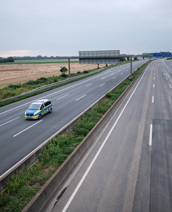 Die gesperrte Autobahn A1 am 16. Juli 2021 bei Blessem in Erftstadt. Ein Polizeiwagen kontrolliert die Strecke.