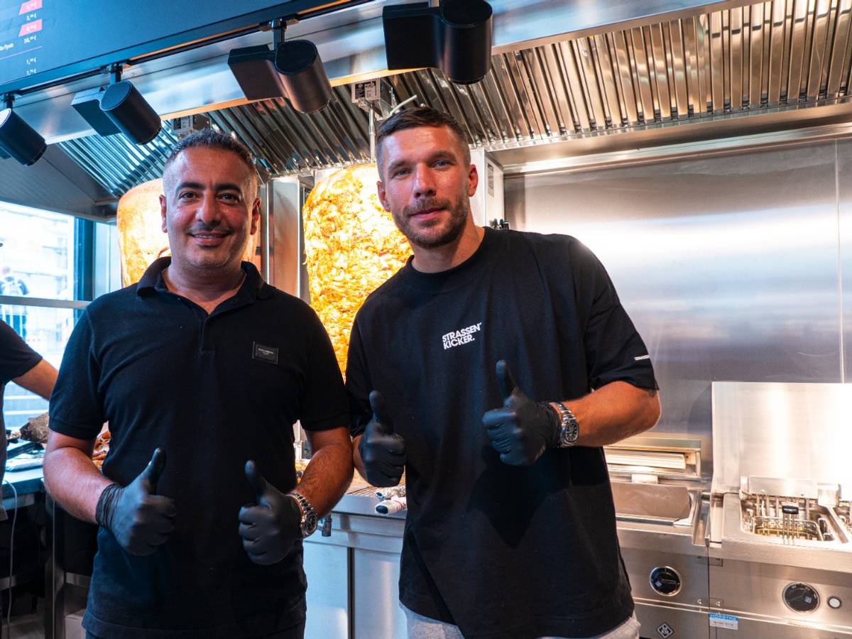 Lukas Podolski steht vor einem Dönerspieß.