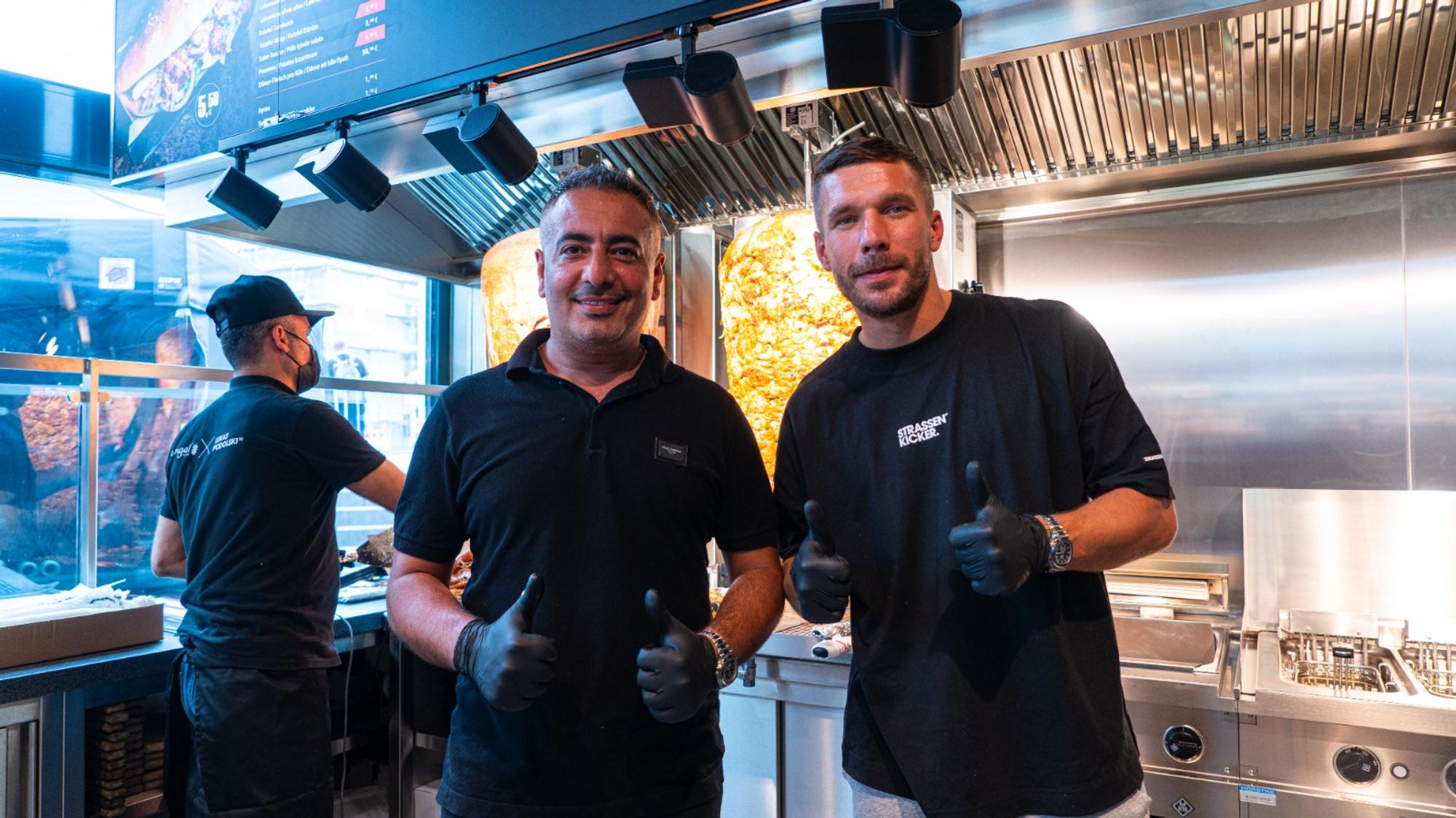 Lukas Podolski steht vor einem Dönerspieß.