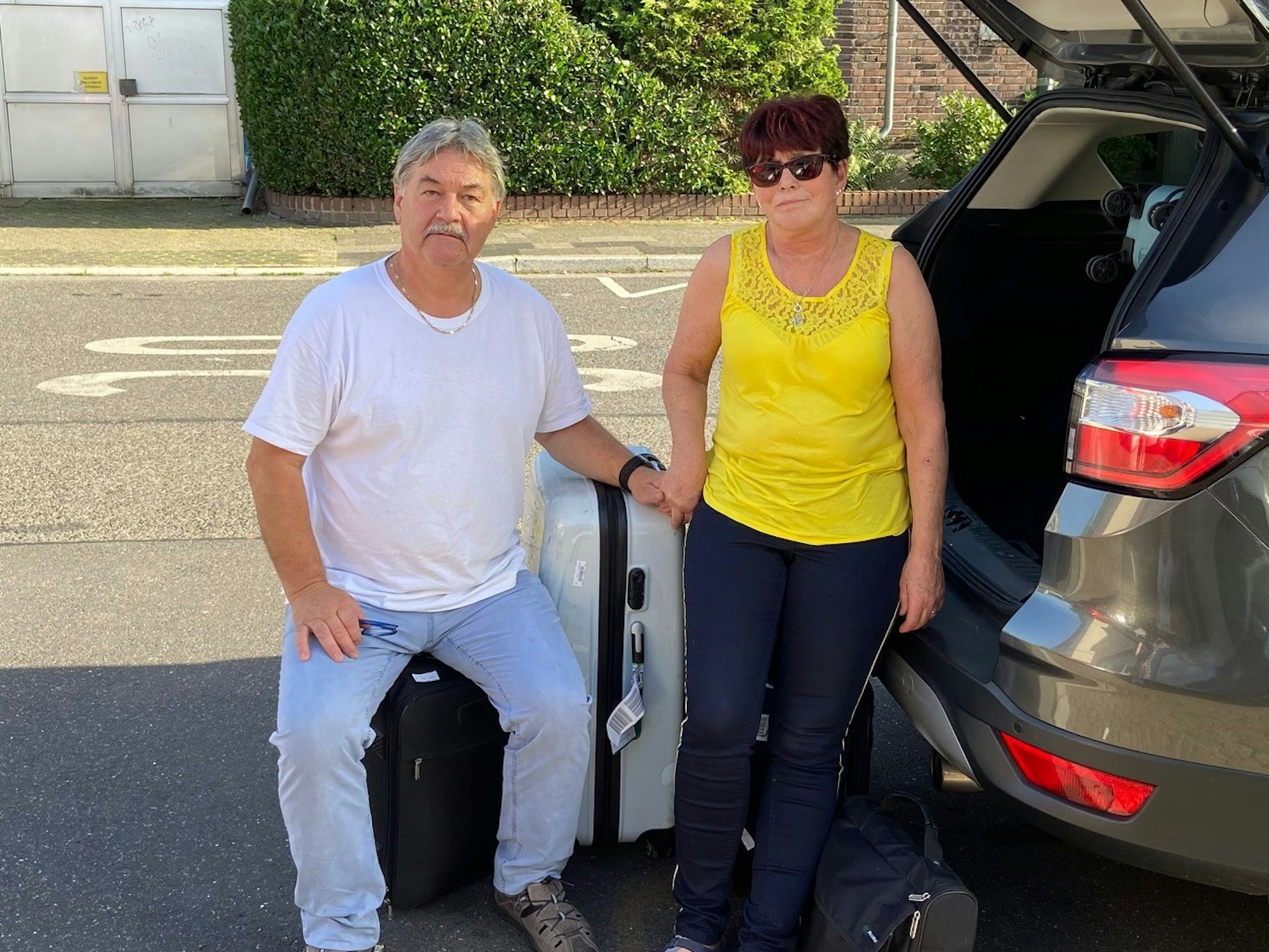 Detlev Knoblauch und seine Frau Käthe mit gepackten Koffern vor dem Auto.
