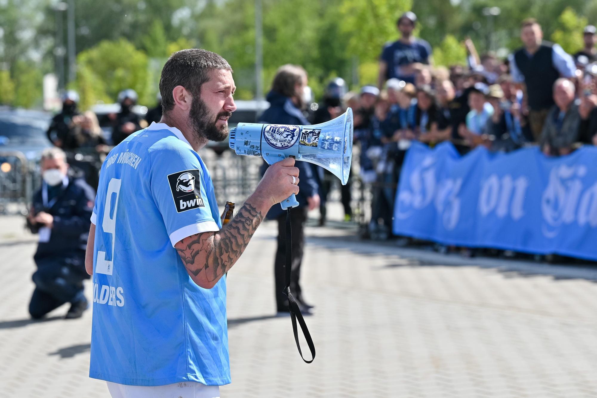 Sascha Mölders mit einem Megaphon in der Hand vor 1860-München-Fans.