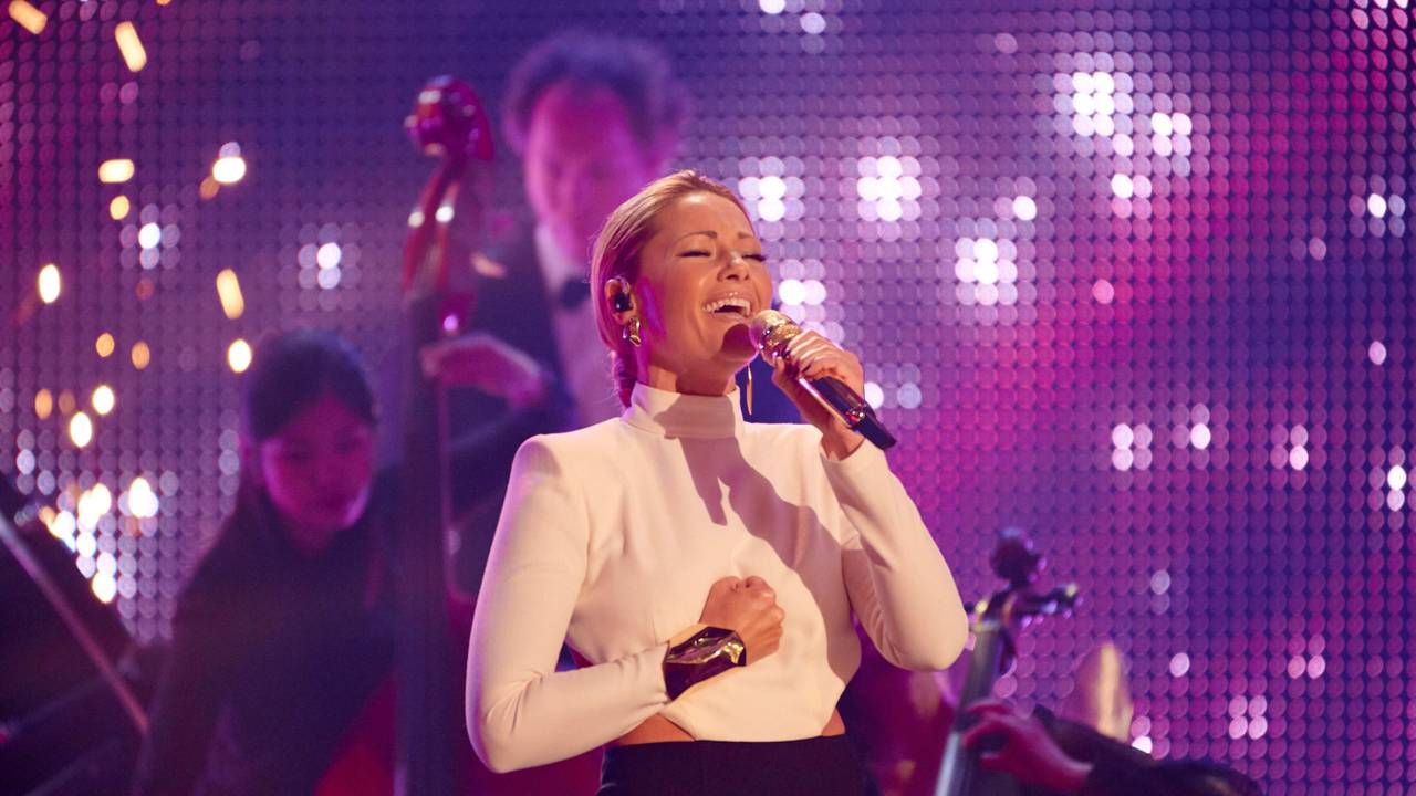 Helene Fischer singt beim RTL-Jahresrückblick mit Mikrofon in der Hand und ihrer Band im Hintergrund.