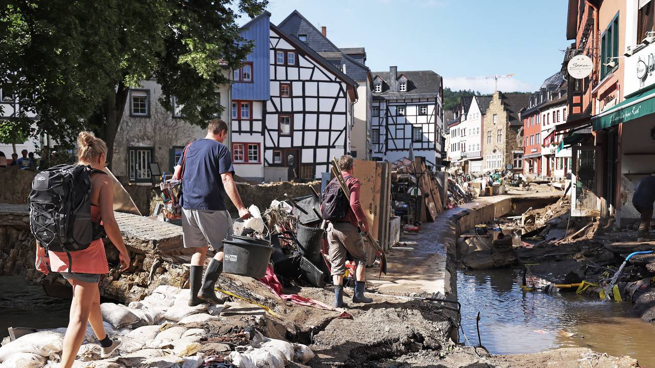 Helfer gehen durch den Ortskern. In Bad Münstereifel hat die über die Ufer getretene Erft erhebliche Schäden angerichtet.