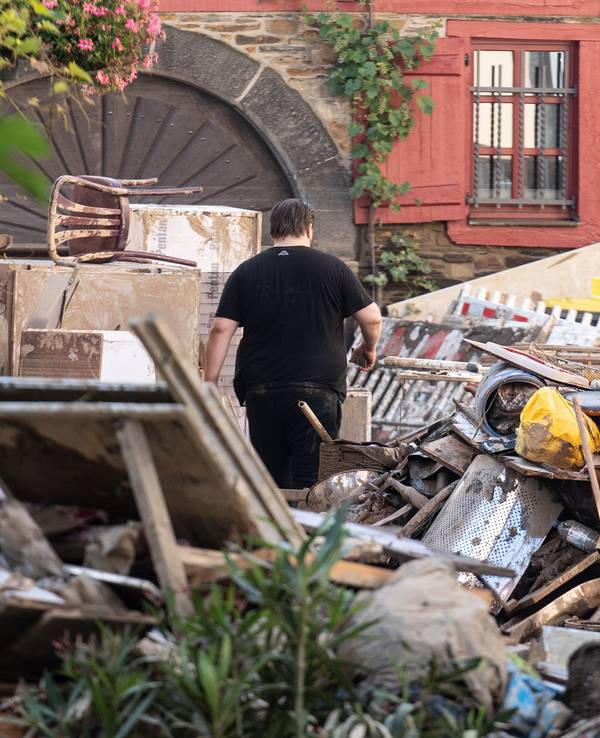Am 18. Juli 2021 läuft ein Anwohner durch die Trümmer-Berge in der Stadt Ahrweiler.