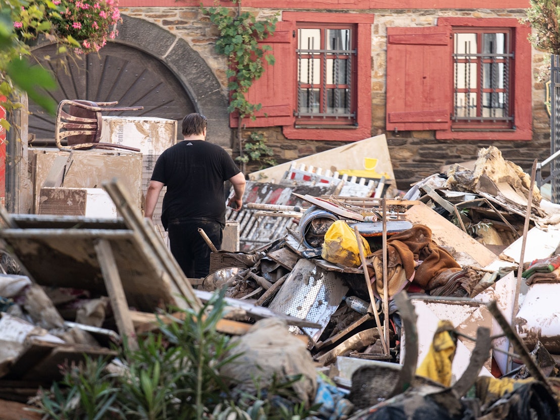 Am 18. Juli 2021 läuft ein Anwohner durch die Trümmer-Berge in der Stadt Ahrweiler.
