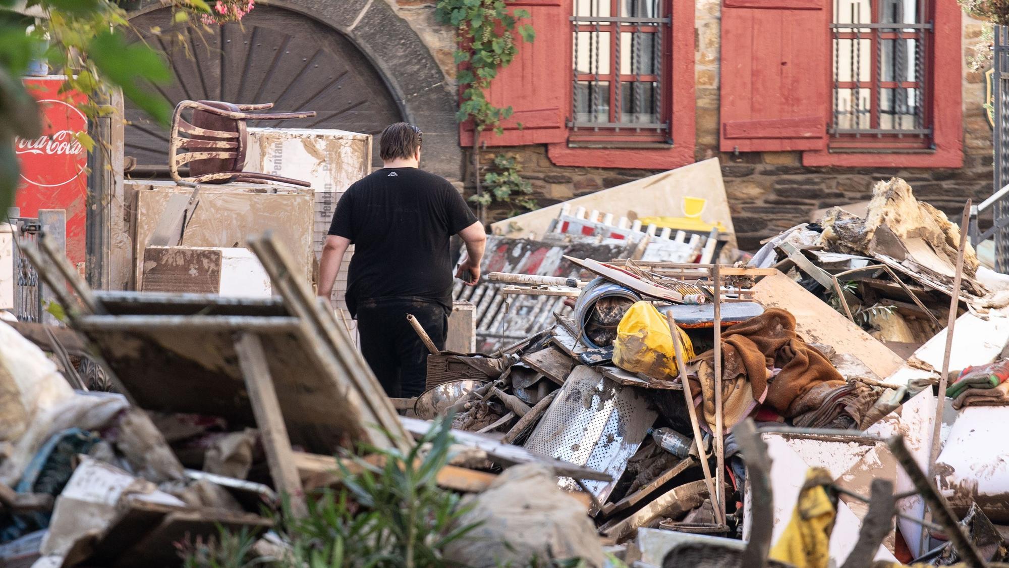 Am 18. Juli 2021 läuft ein Anwohner durch die Trümmer-Berge in der Stadt Ahrweiler.