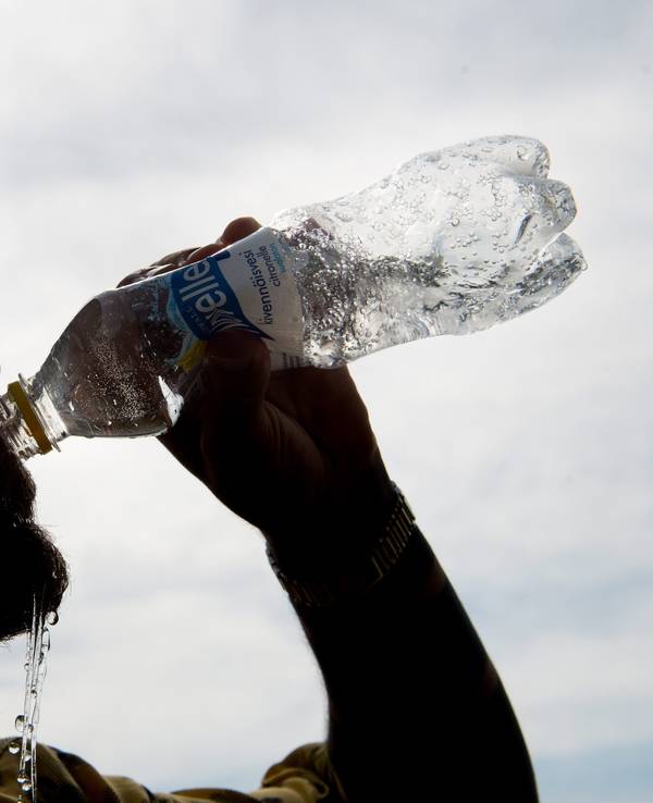 Auf unseren Symbolfoto ist ein Mann mit Mütze zu sehen, der aus einer Flasche Wasser trinkt.