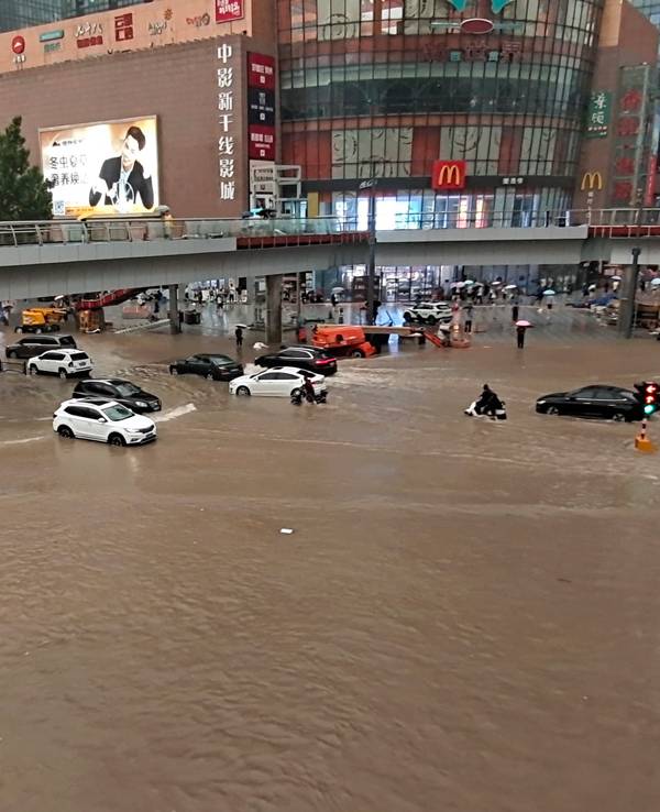 Fahrzeuge stehen in der zentralchinesischen Provinz Henan auf einer überfluteten Straße.