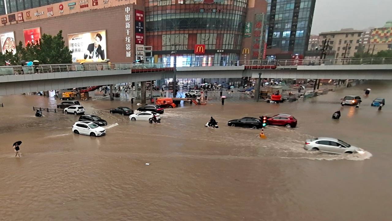 Fahrzeuge stehen in der zentralchinesischen Provinz Henan auf einer überfluteten Straße.