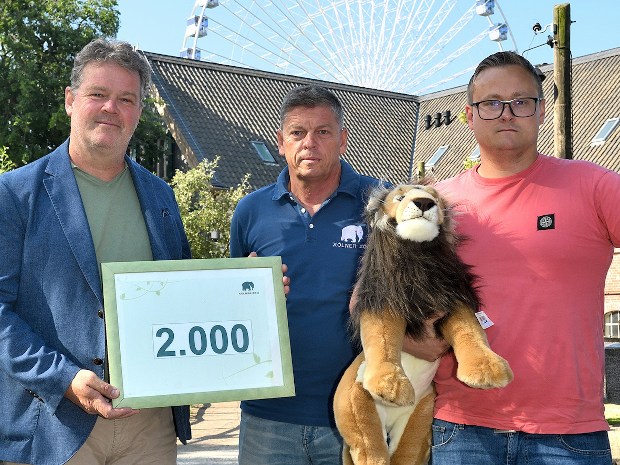 Drei Männer zeigen Plakat für 2000 Zoo-Tickets an Opfer der Flut-Katastrophe.