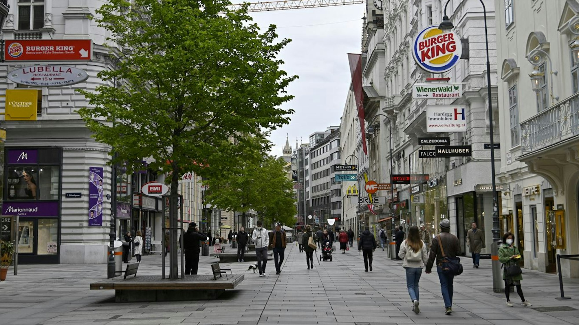 In einer Fußgängerzone in Wien spazieren einige Menschen umher.