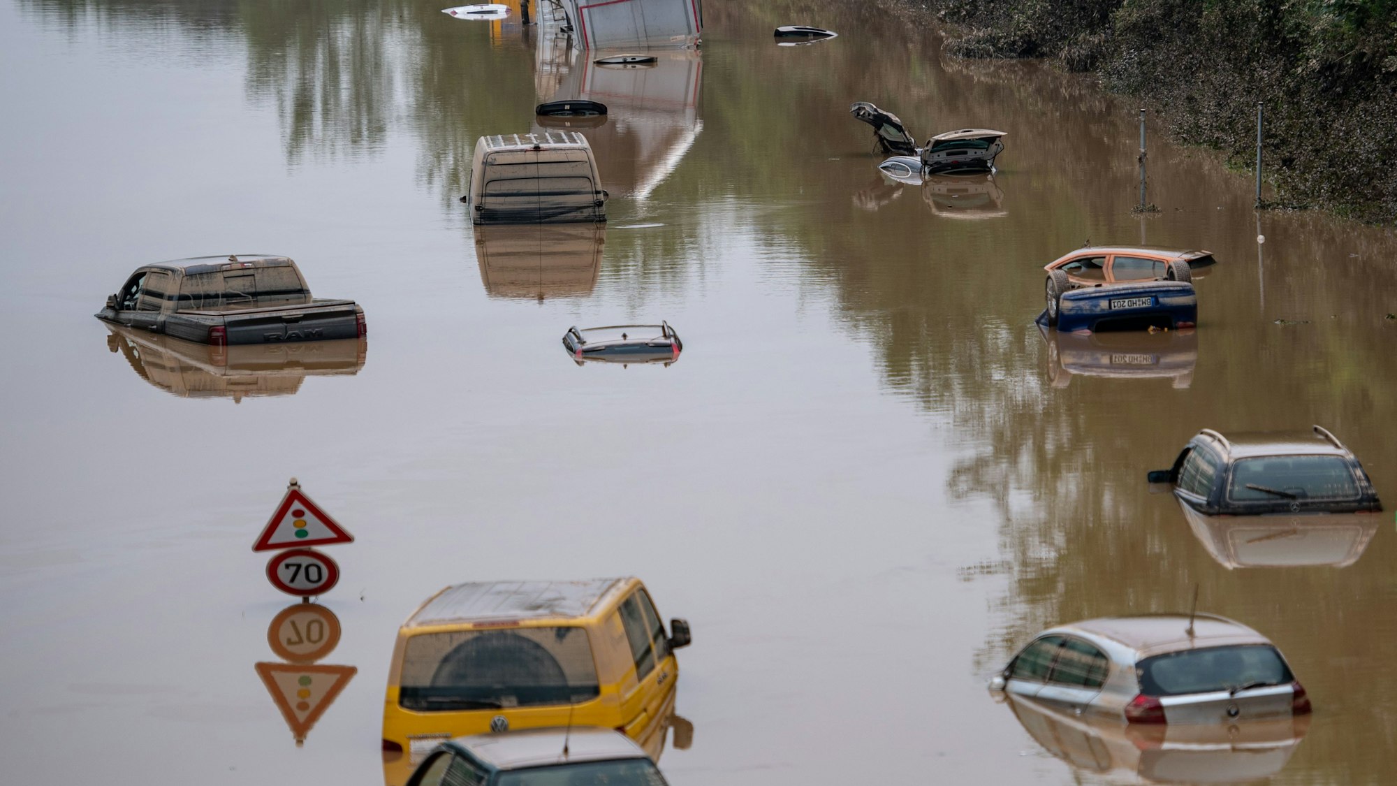 Autos stehen auf der überfluteten Bundesstraße 265 in Erftstadt im Wasser.
