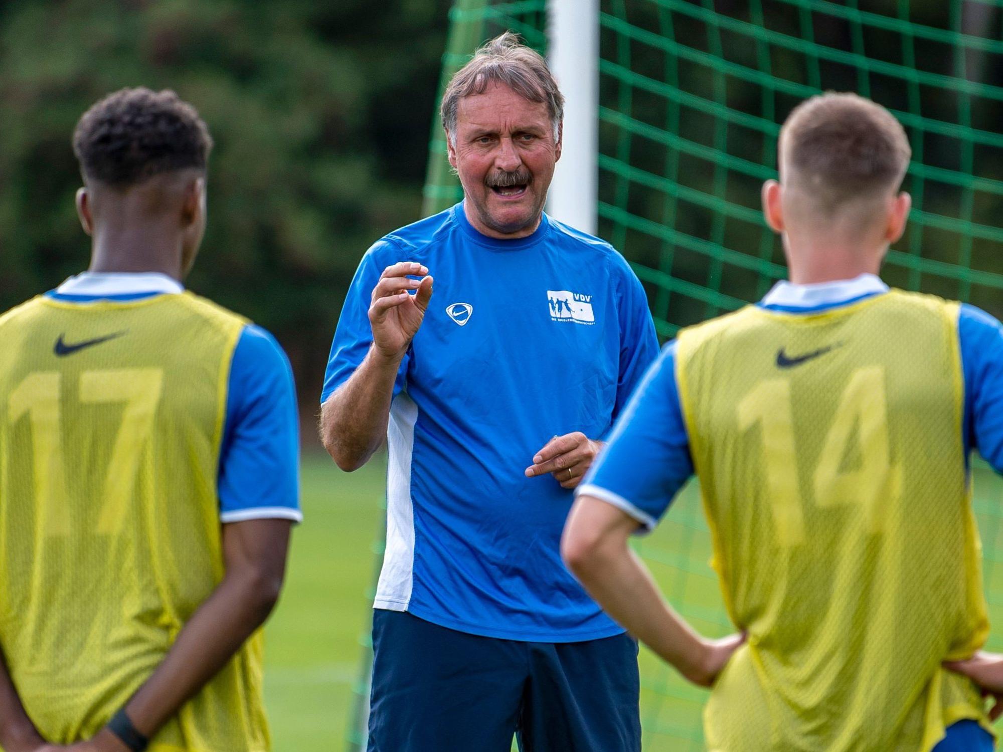 Peter Neururer erklärt Spielern etwas im Training