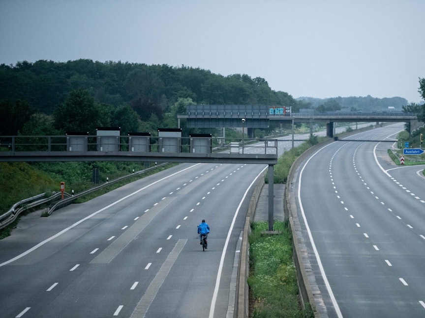 Ein Fahrradfahrer fährt über die gesperrte Autobahn A1 nahe Blessem in Erftstadt.