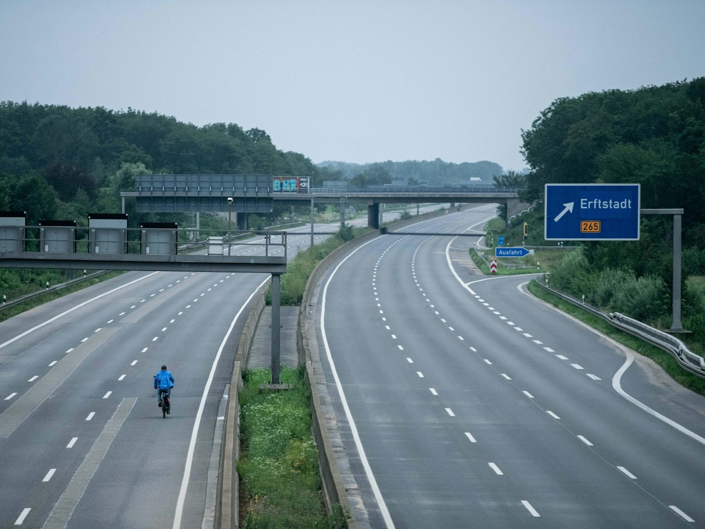 Ein Fahrradfahrer fährt über die gesperrte Autobahn A1 nahe Blessem in Erftstadt.