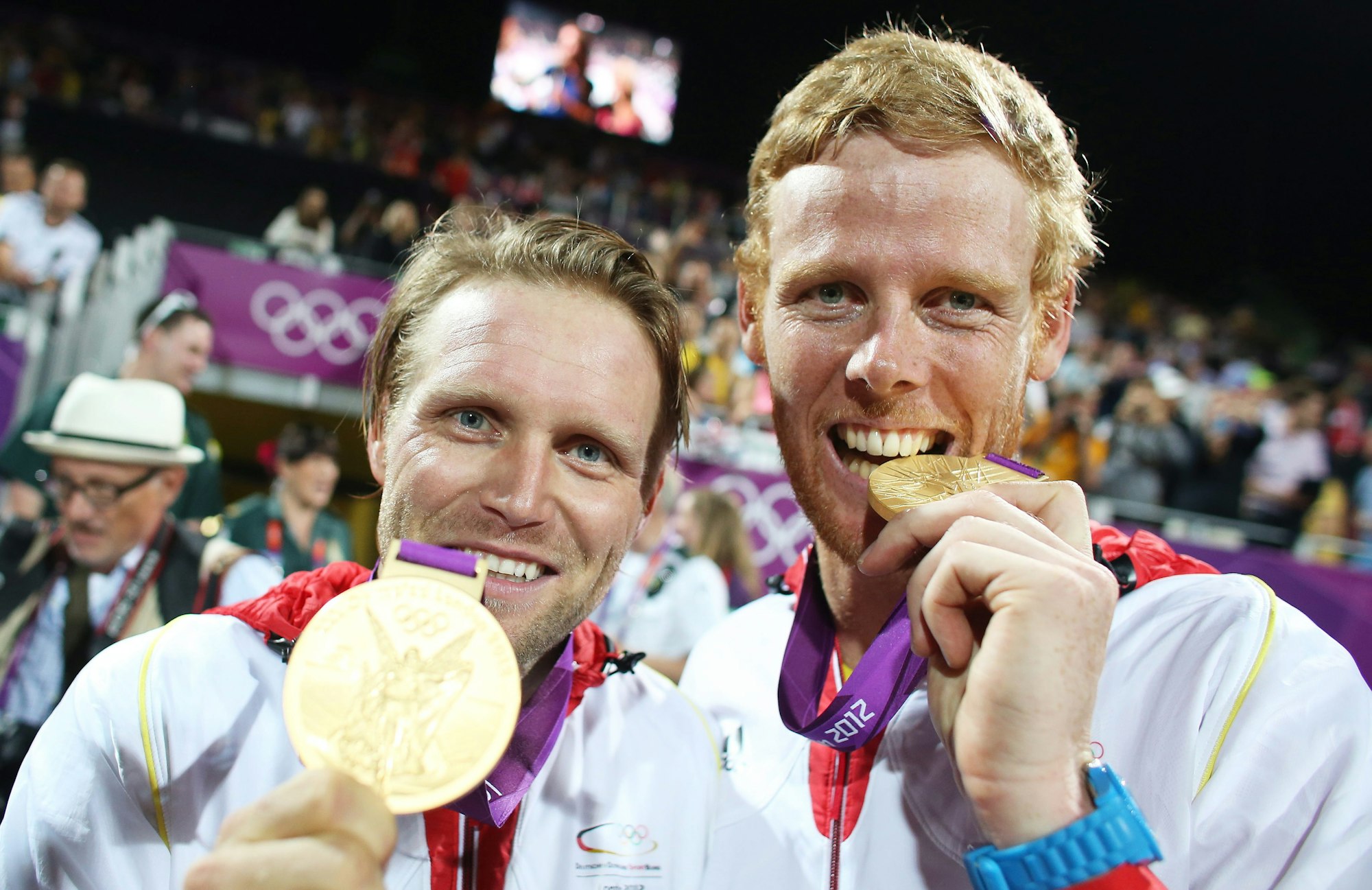 Julius Brink (l.) und Jonas Reckermann zeigen nach Olympia-Gold 2012 in London ihre Medaillen.