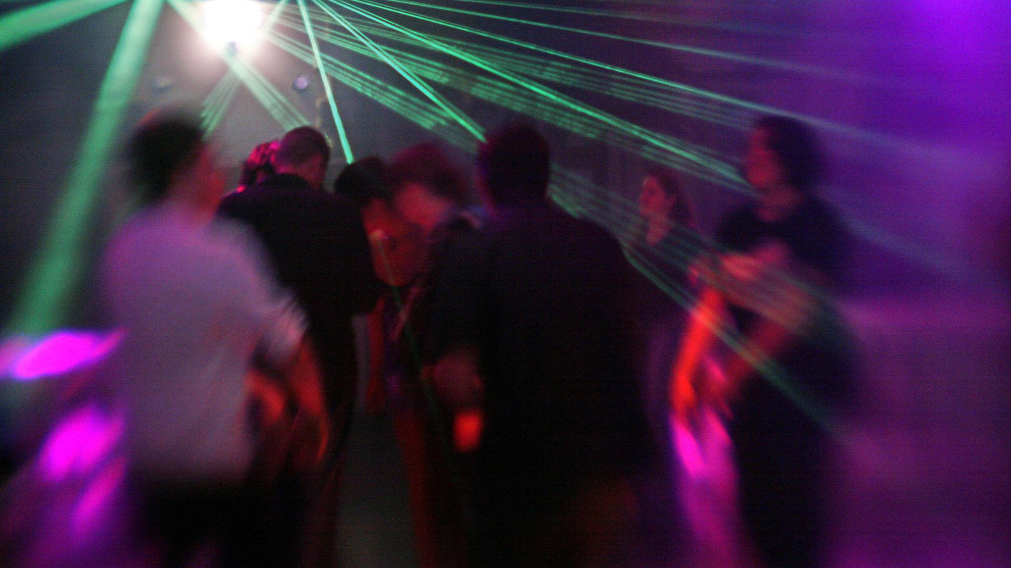 Menschen feiern auf der Tanzfläche einer Discothek (Symbolfoto)