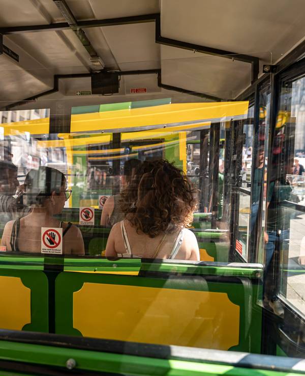 Ein Bimmelbahn fährt mit Passagieren durch Köln.