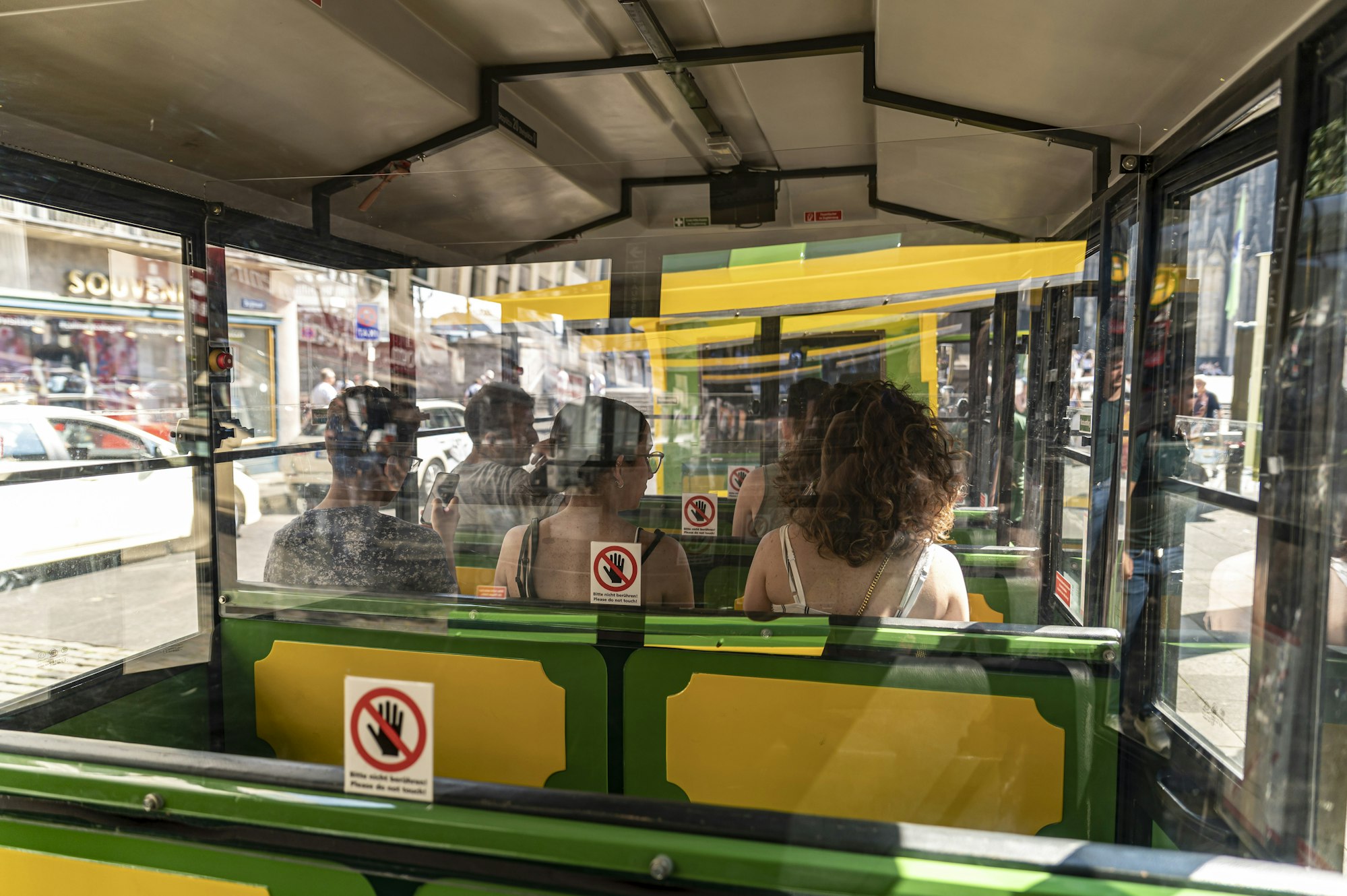 Ein Bimmelbahn fährt mit Passagieren durch Köln.