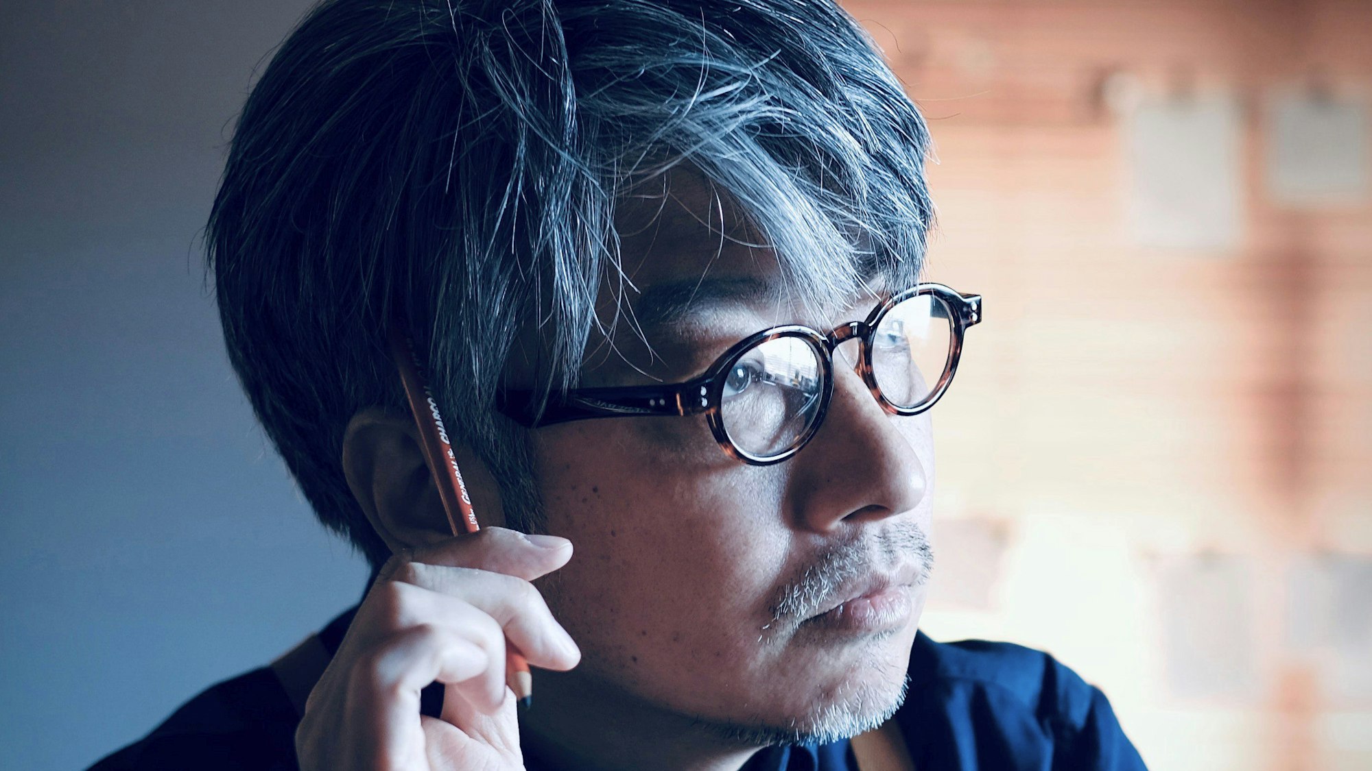 Kentaro Kobayashi grübelt und kratzt sich mit einem Stift am Kopf.