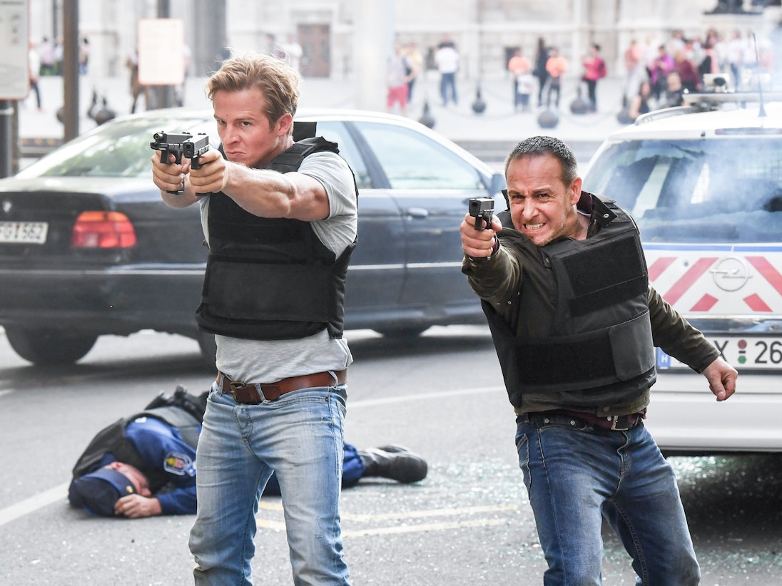 Erdogan Atalay und Daniel Roesner stehen mit gezückten Pistolen in den Händen bei einer Schießszene der RTL-Action-Serie ´Alarm für Cobra 11 - Die Autobahnpolizei” im Set.