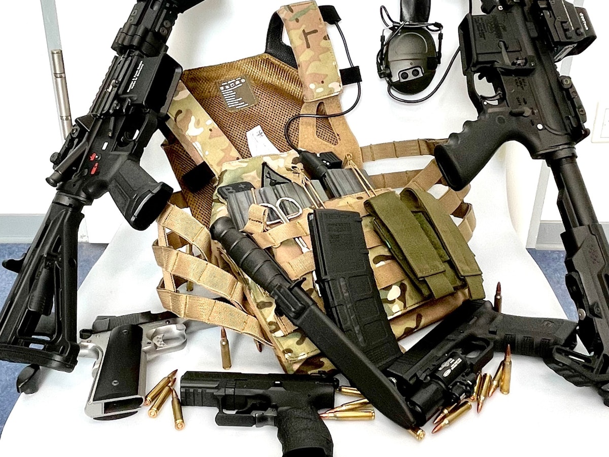 Mehrere Waffen, darunter zwei Sturmgewehre, liegen auf einem Haufen.