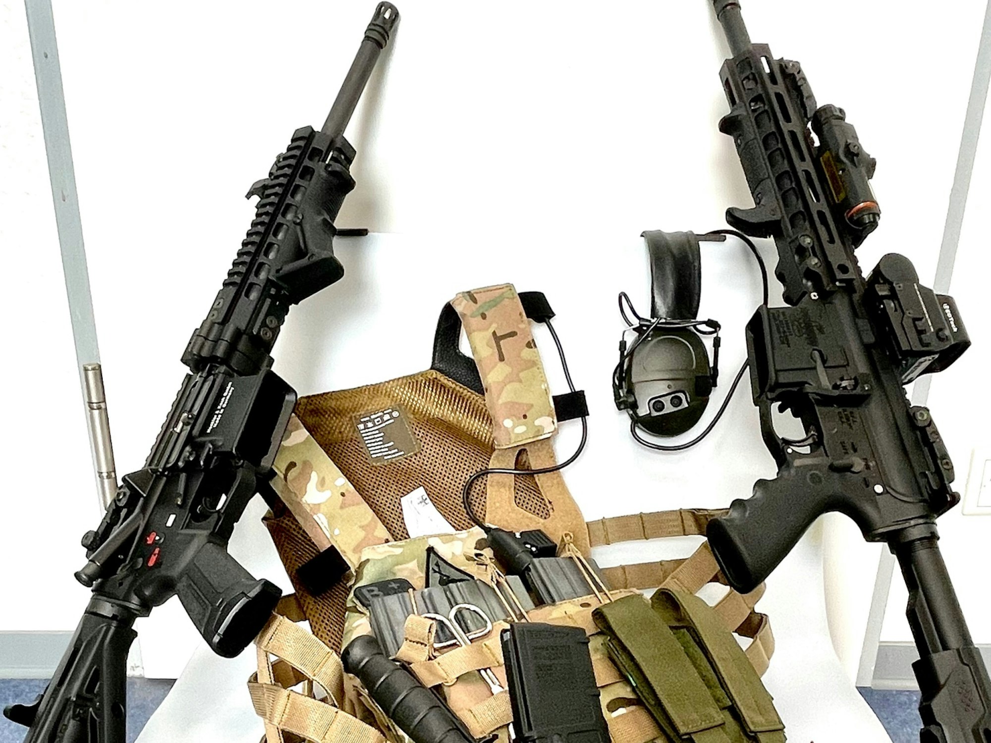 Mehrere Waffen, darunter zwei Sturmgewehre, liegen auf einem Haufen.