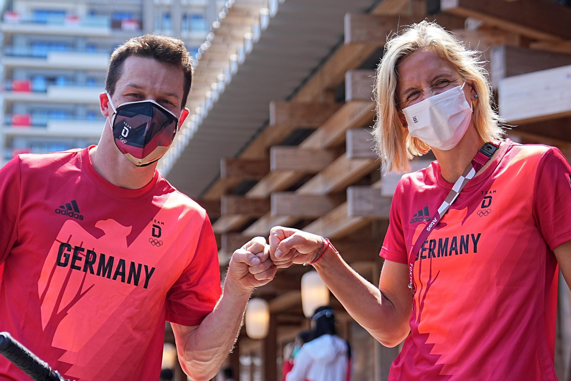 Wasserspringer Patrick Hausding (l) und Beachvolleyballspielerin Laura Ludwig begrüßen per Faustschlag vor der Pressekonferenz in Tokio.