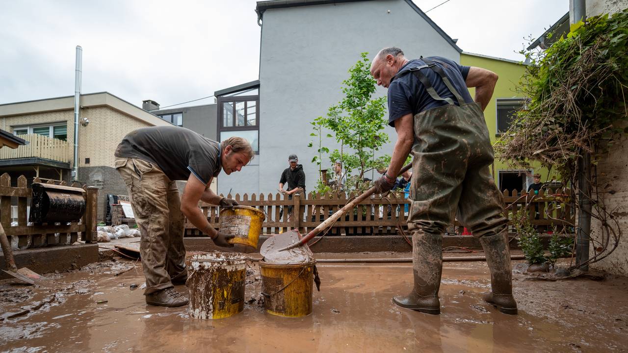 Mit Eimern entsorgen Anwohner die Schlammmassen nach dem Hochwasser der Kyll.
