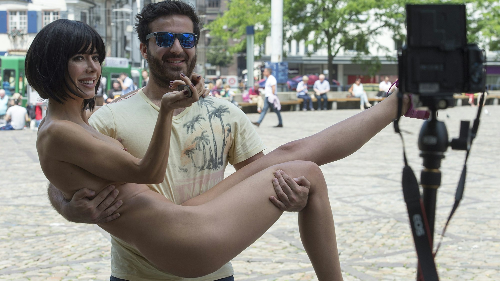 Milo Moiré wird bei einer Performance von einem Passanten getragen