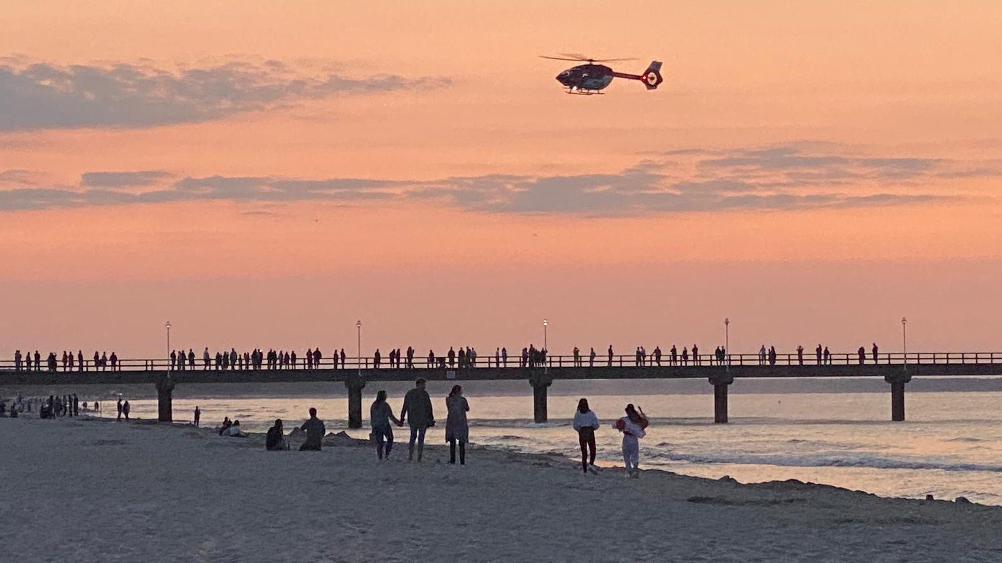 Ein Rettungshubschrauber fliegt über die Seebrücke im Ostseebad Zinnowitz.