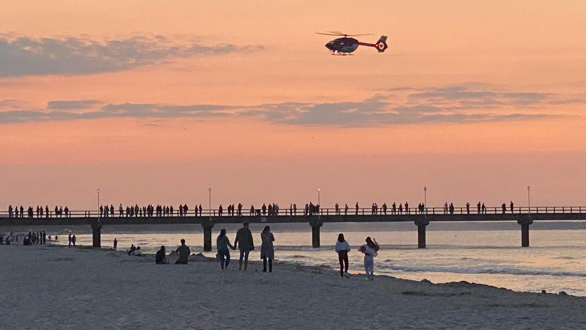 Ein Rettungshubschrauber fliegt über die Seebrücke im Ostseebad Zinnowitz.