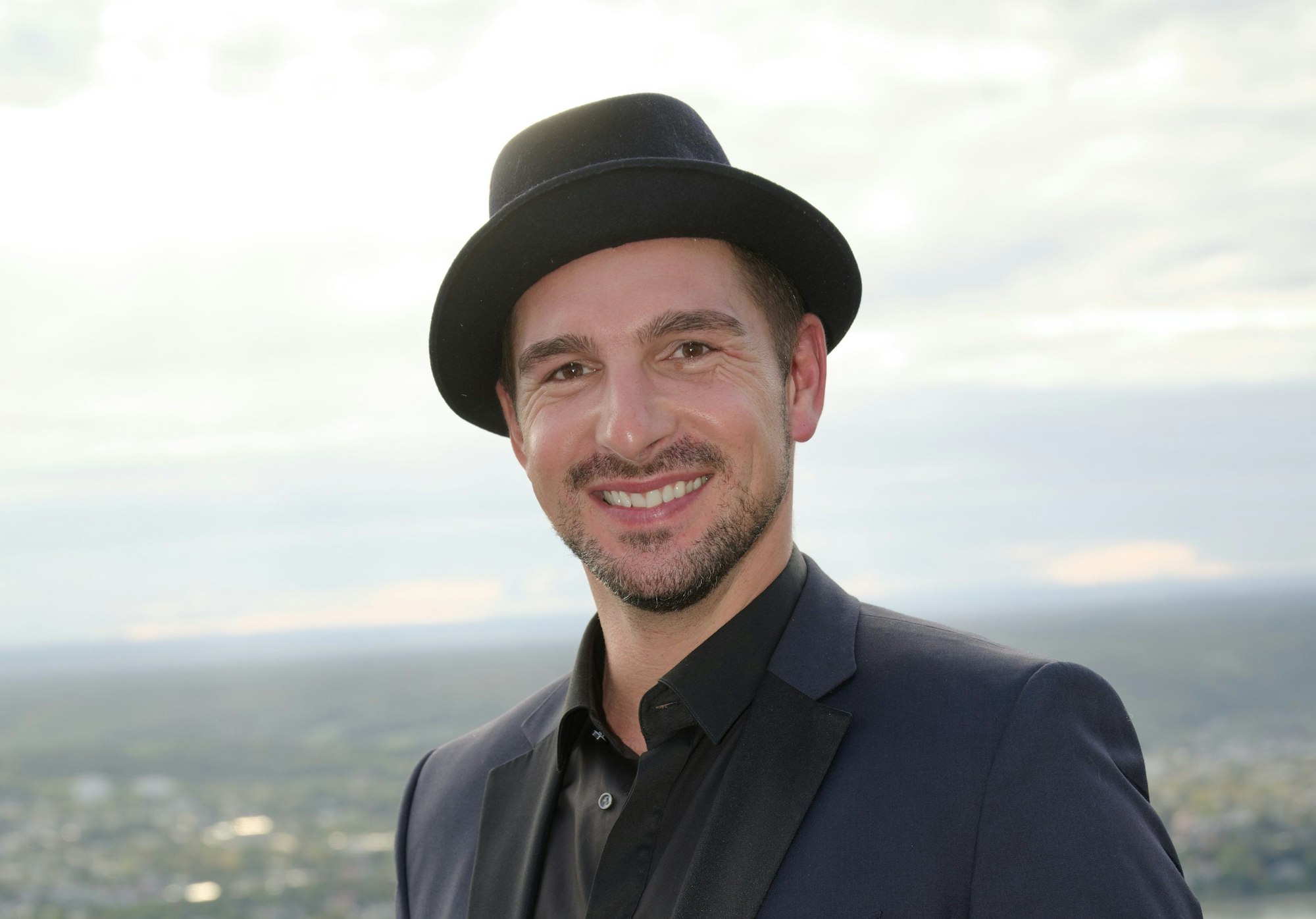 Schauspieler Benjamin Piwko posiert mit Hut bei der Wiedereröffnung des Hotels Petersberg im September 2019.