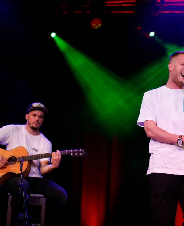 Rapper Mo-Torres steht in der Mitte auf der Bühne und singt.