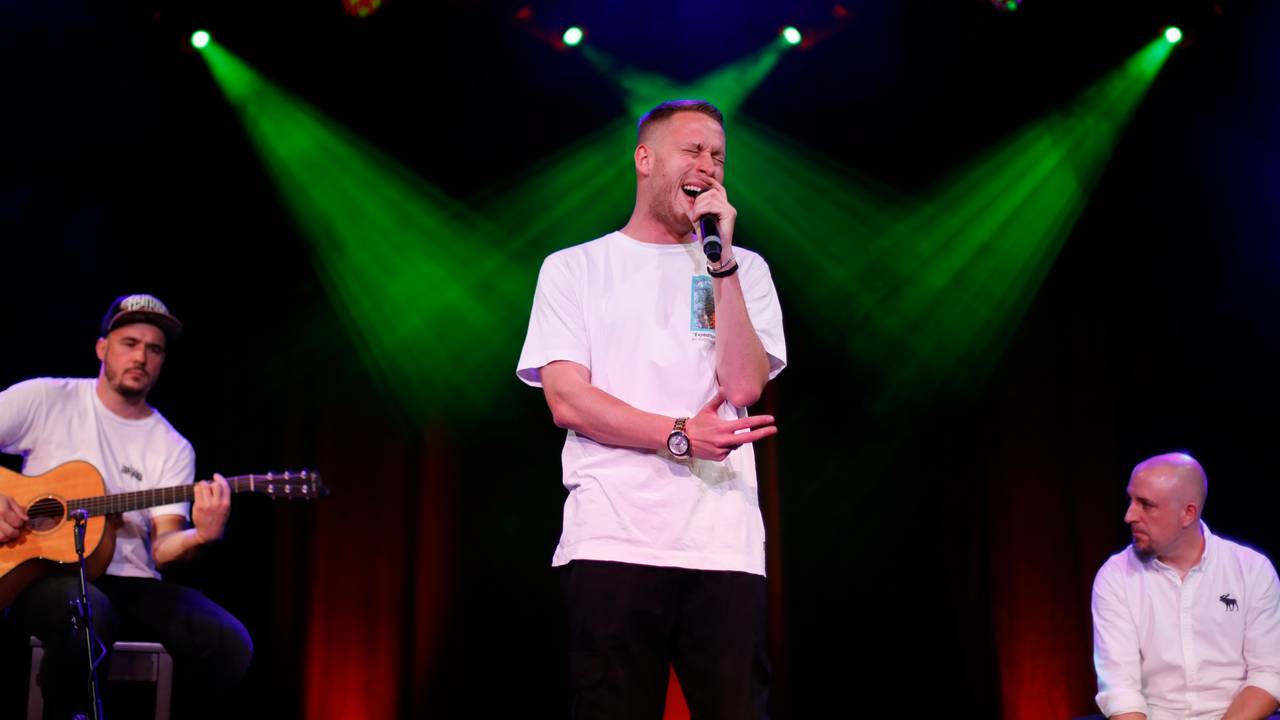 Rapper Mo-Torres steht in der Mitte auf der Bühne und singt.