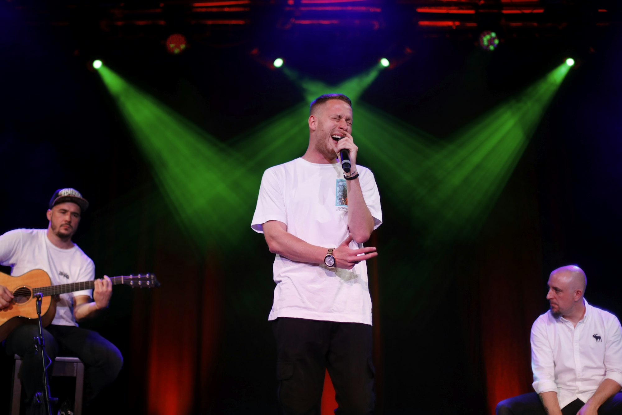 Rapper Mo-Torres steht in der Mitte auf der Bühne und singt.