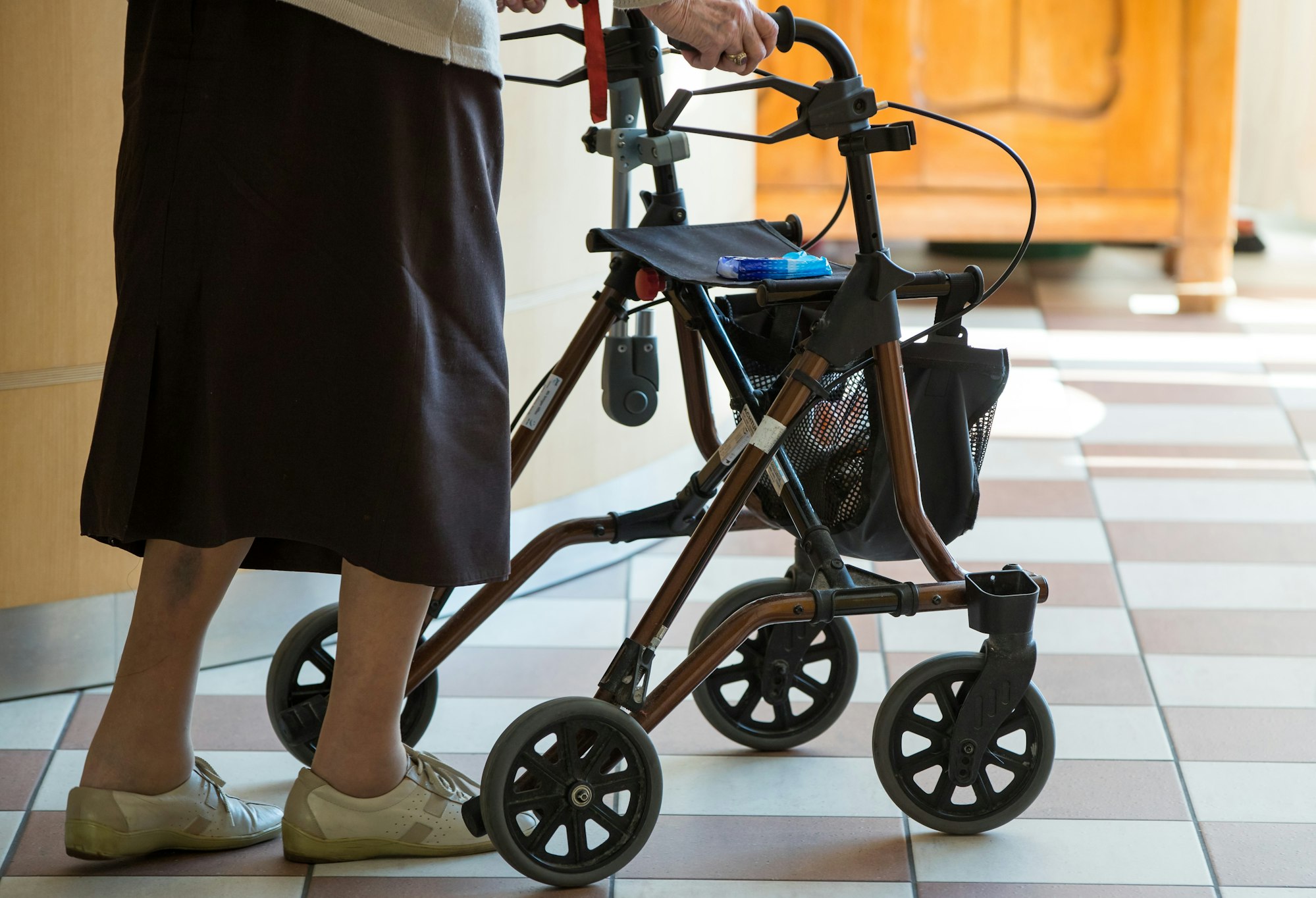 Eine alte Frau schiebt einen Rollator.