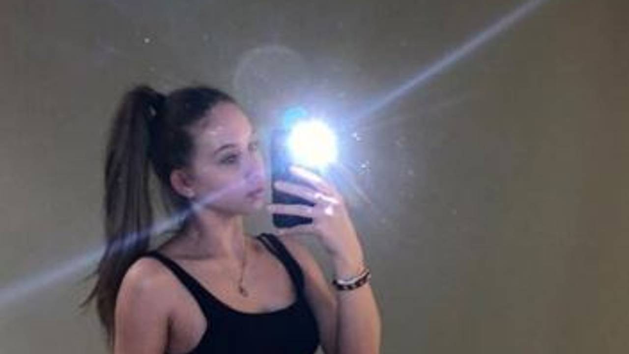 Shania Geiss steht vor einem Spiegel und fotografiert sich selbst mit dem Handy.