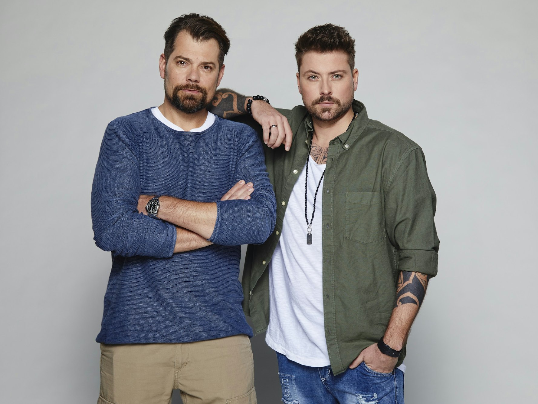 Daniel Fehlow steht mit verschränkten Armen links. Rechts neben ihm steht Felix von Jascherof, der seinen Arm auf Daniels Schulter legt.