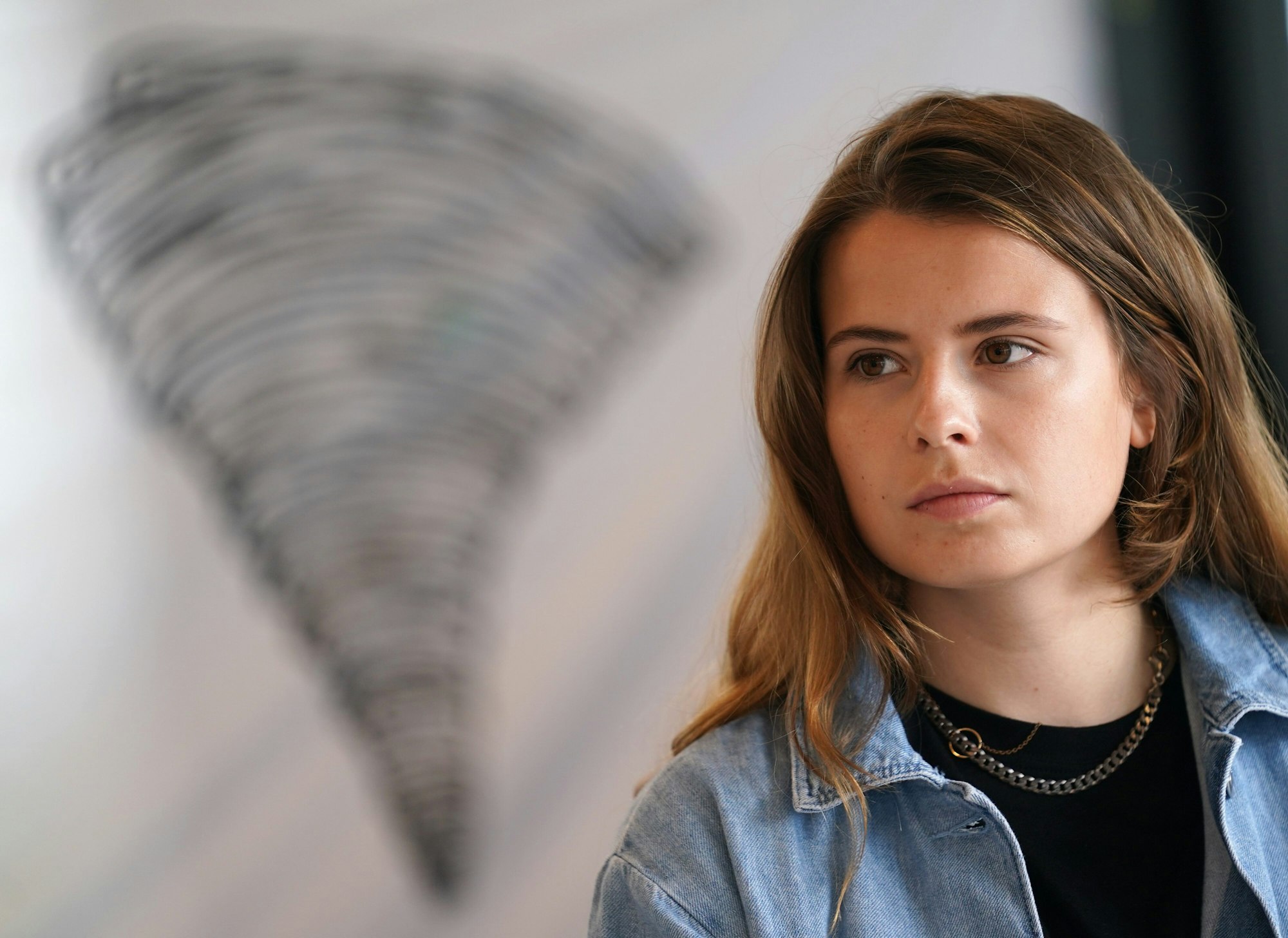 Klima-Aktivistin Luisa Neubauer sitzt während einer Pressekonferenz des Bündnisses Fridays for Future am 23.07.2021 vor dem Symbol eines Tornados.