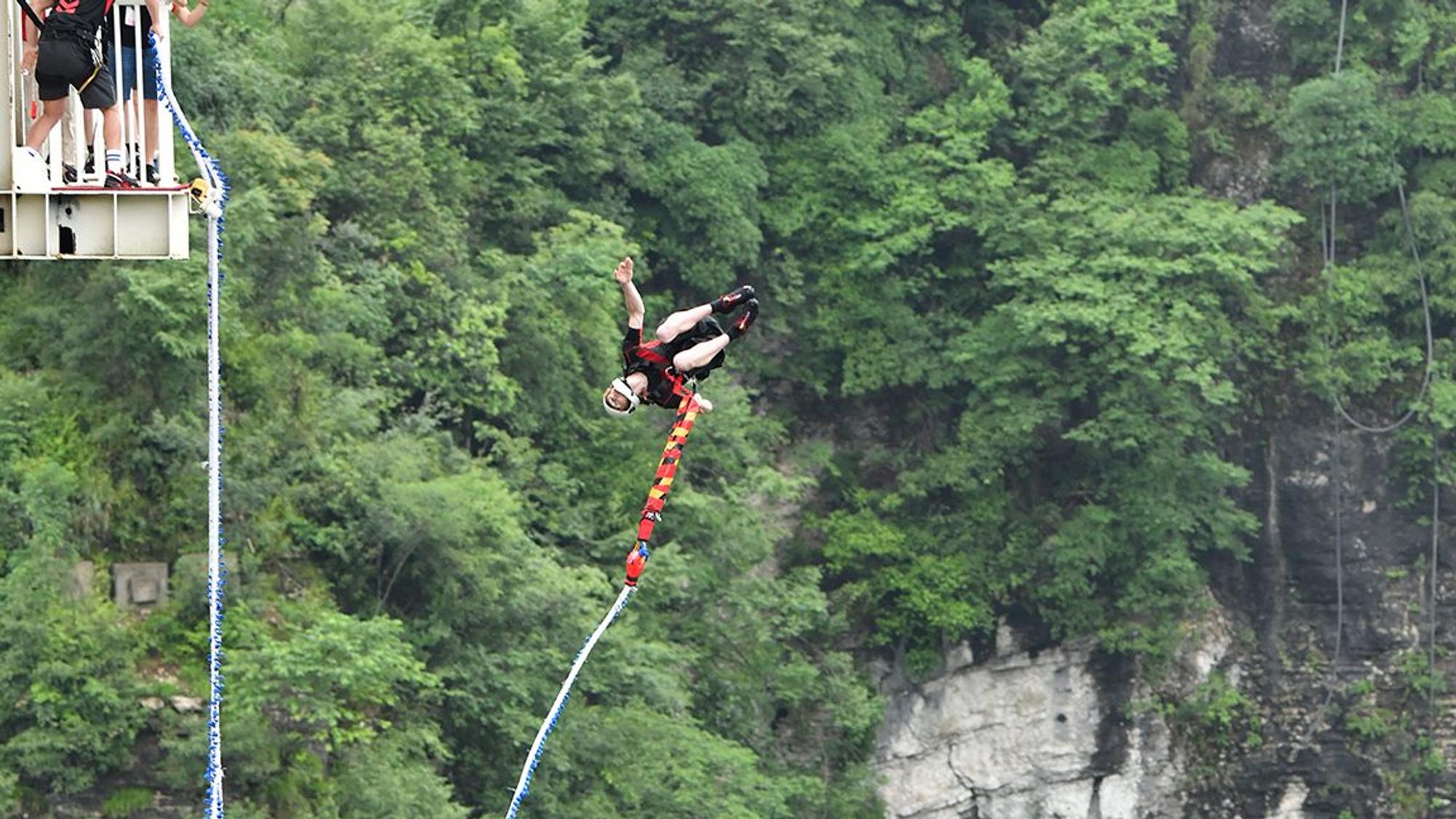 Ein Bungeespringer springt von der Glasbrücke Zhangjiajie in China.