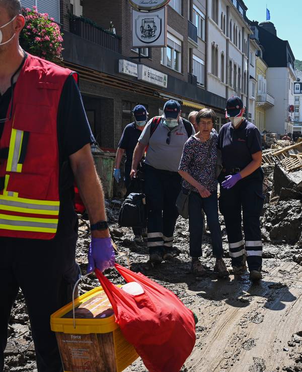 Helfende der Johanniter in Bad Neuenahr-Ahrweiler begleiten eine Seniorin aus ihrer Wohnung.
