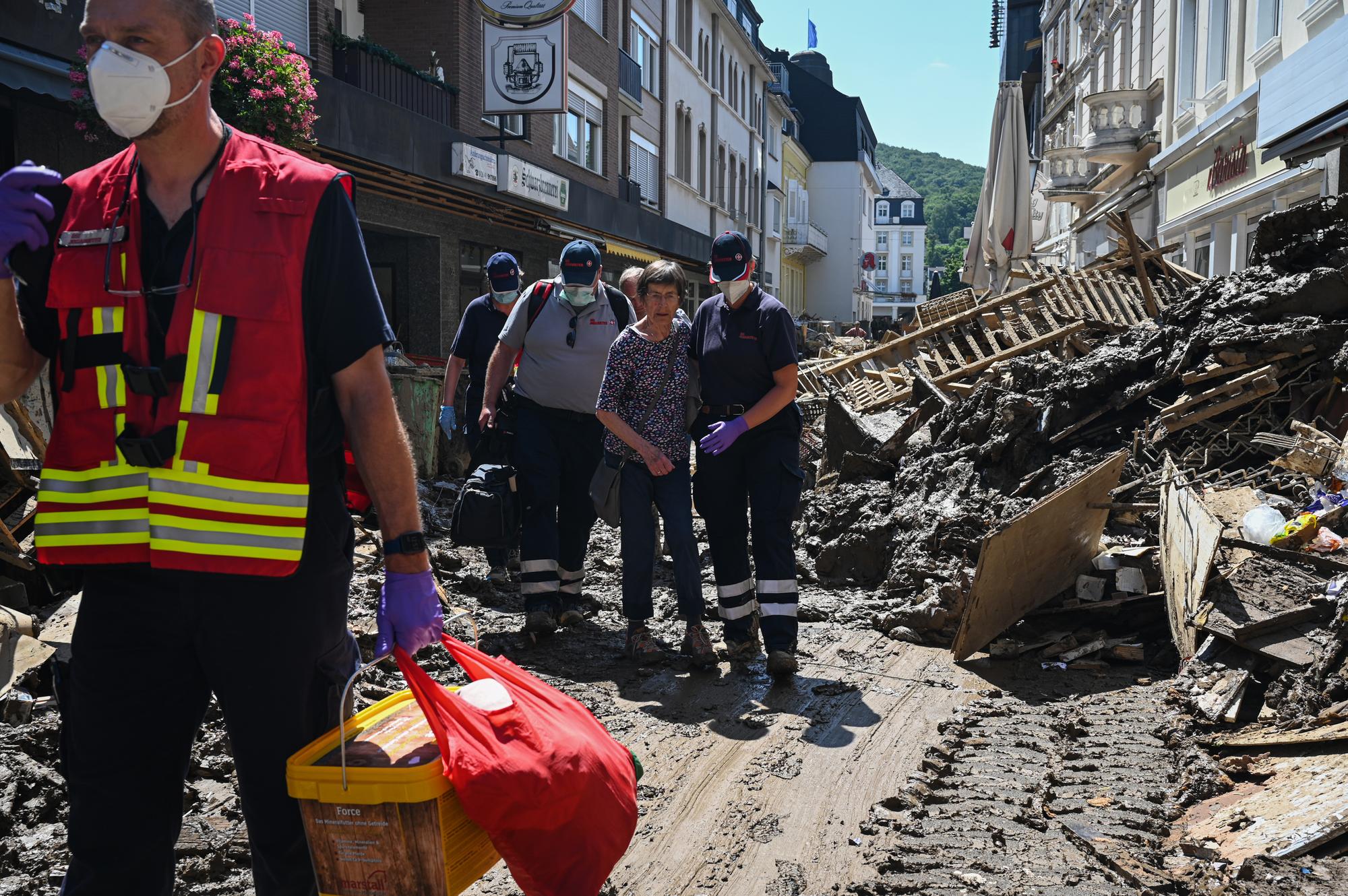 Helfende der Johanniter in Bad Neuenahr-Ahrweiler begleiten eine Seniorin aus ihrer Wohnung.