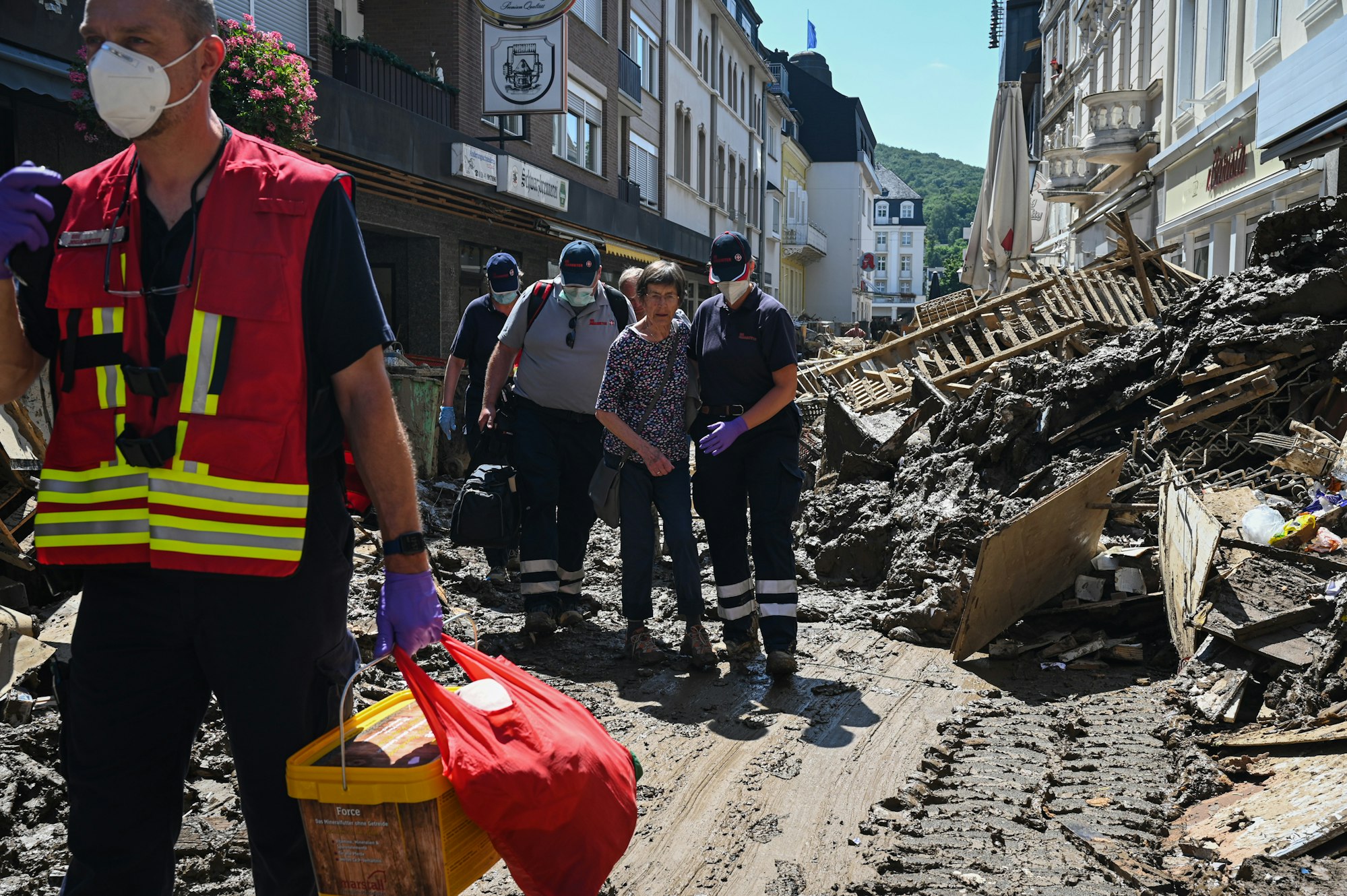 Helfende der Johanniter in Bad Neuenahr-Ahrweiler begleiten eine Seniorin aus ihrer Wohnung.